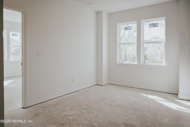 spare room with baseboards and unfinished concrete floors