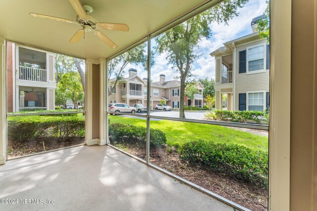 unfurnished sunroom with ceiling fan