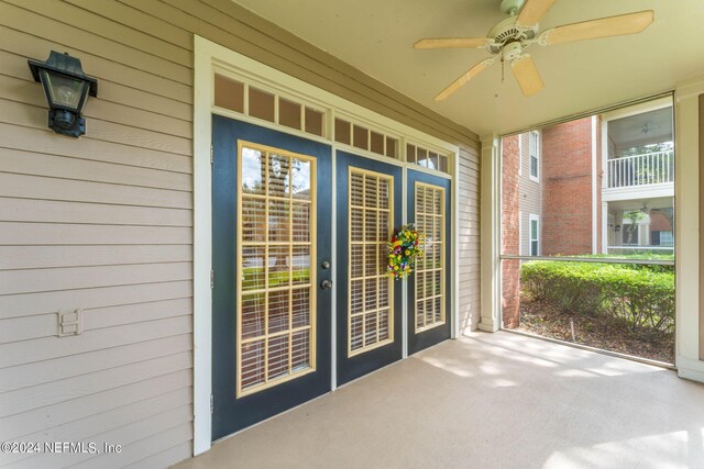 view of exterior entry featuring ceiling fan and a patio area