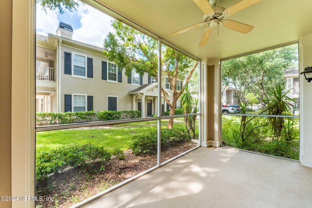 unfurnished sunroom featuring a healthy amount of sunlight and ceiling fan