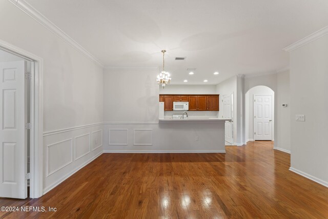 interior space featuring crown molding, hardwood / wood-style flooring, and a chandelier