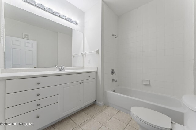 full bathroom with tiled shower / bath, vanity, toilet, and tile patterned flooring