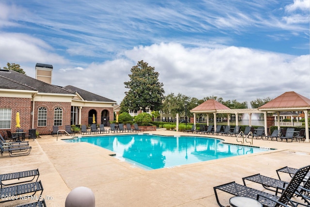 community pool featuring fence and a patio