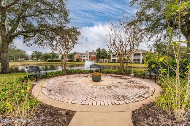 surrounding community with a patio area and a water view