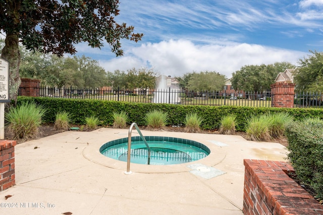 view of pool featuring a patio area, fence, and a hot tub