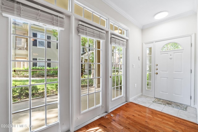 entrance foyer with light wood finished floors, baseboards, and ornamental molding