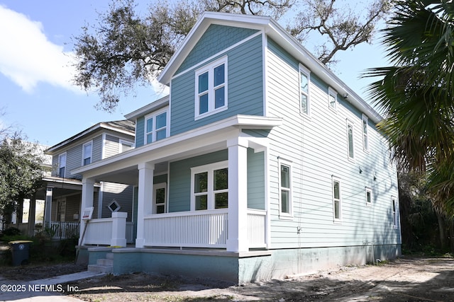 american foursquare style home featuring a porch