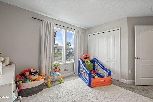 game room featuring a textured ceiling and light colored carpet