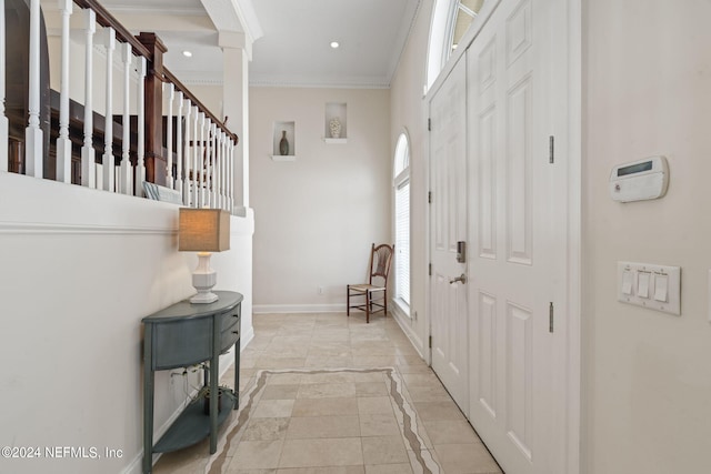 tiled entrance foyer with crown molding and decorative columns