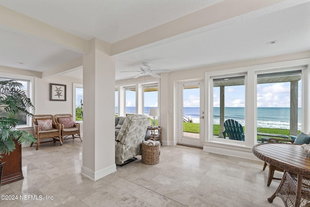 sunroom featuring a water view