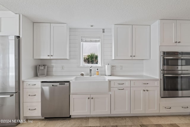 kitchen with white cabinets, appliances with stainless steel finishes, light countertops, and a sink