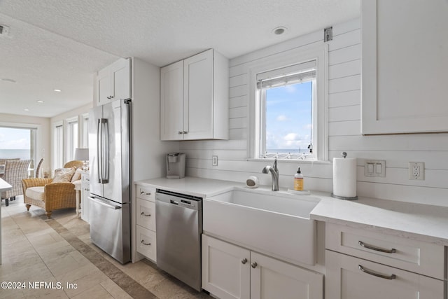 kitchen with visible vents, a sink, a textured ceiling, white cabinetry, and stainless steel appliances