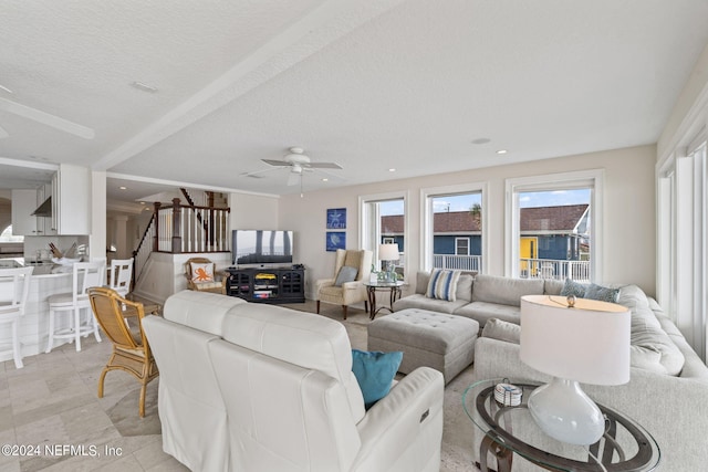 living room with a textured ceiling and ceiling fan