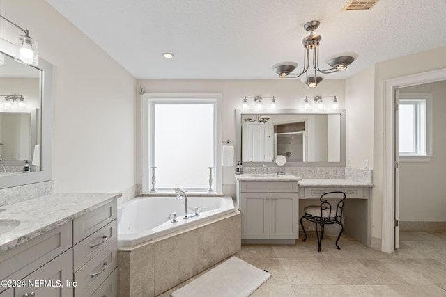 bathroom with visible vents, two vanities, a stall shower, a bath, and a sink