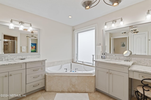 bathroom featuring a bath, a stall shower, two vanities, and a sink