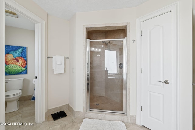 bathroom with toilet, tile patterned floors, walk in shower, and a textured ceiling