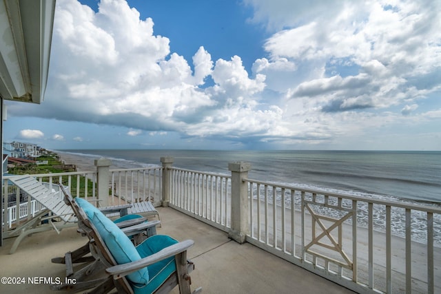 balcony featuring a beach view and a water view