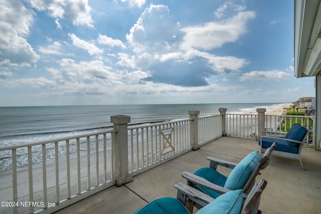 balcony featuring a beach view and a water view