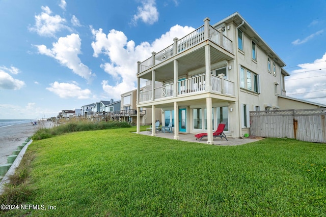 back of house featuring a patio, a lawn, fence, and stucco siding