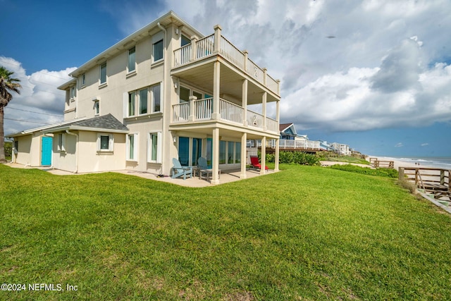 back of property featuring a patio area, stucco siding, a yard, and a balcony