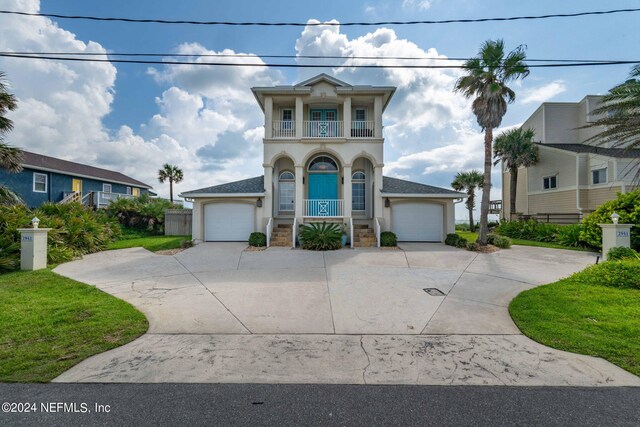 view of front of property with a balcony, a front yard, a garage, and a porch