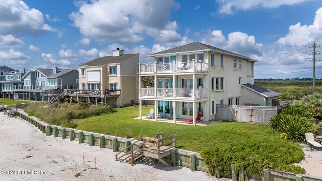 back of house with a patio, a yard, and a balcony