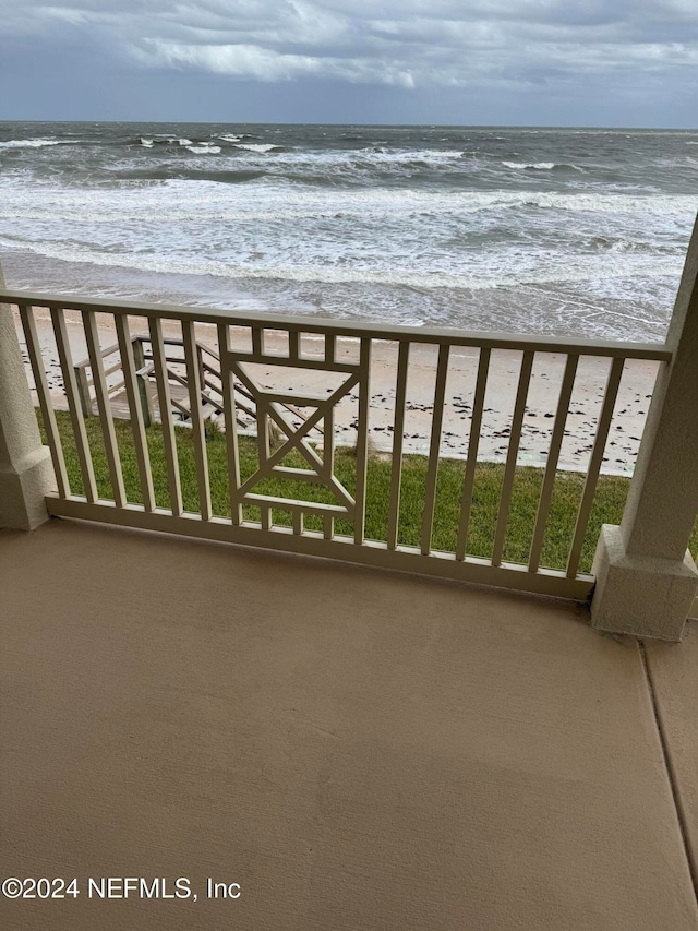 balcony featuring a water view and a view of the beach