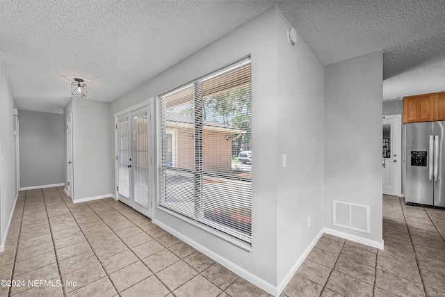 interior space with light tile patterned floors and a textured ceiling