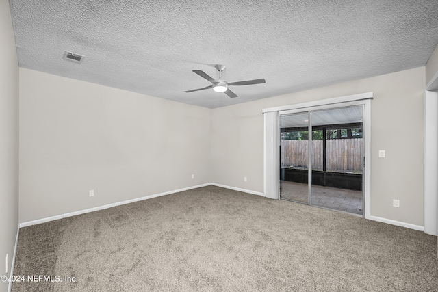 carpeted empty room featuring ceiling fan and a textured ceiling