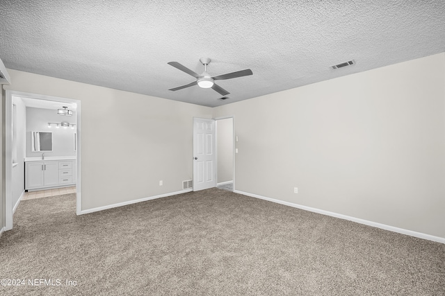 carpeted empty room featuring ceiling fan and a textured ceiling