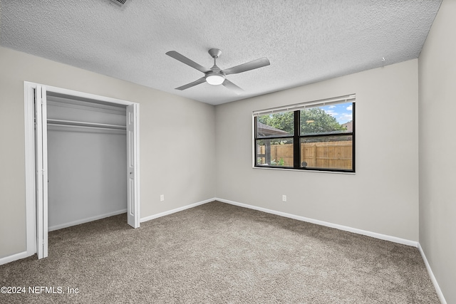 unfurnished bedroom featuring carpet flooring, a closet, ceiling fan, and a textured ceiling