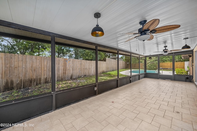 unfurnished sunroom featuring ceiling fan