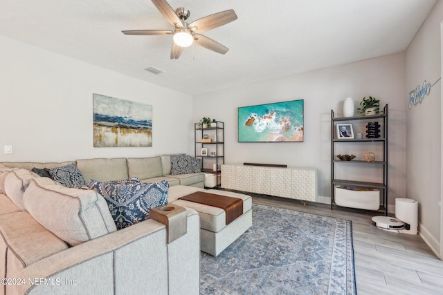 living room featuring light hardwood / wood-style flooring and ceiling fan