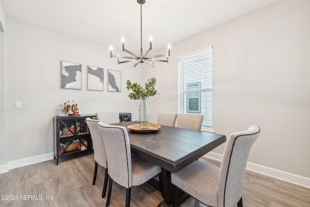 dining area with a notable chandelier and light hardwood / wood-style flooring