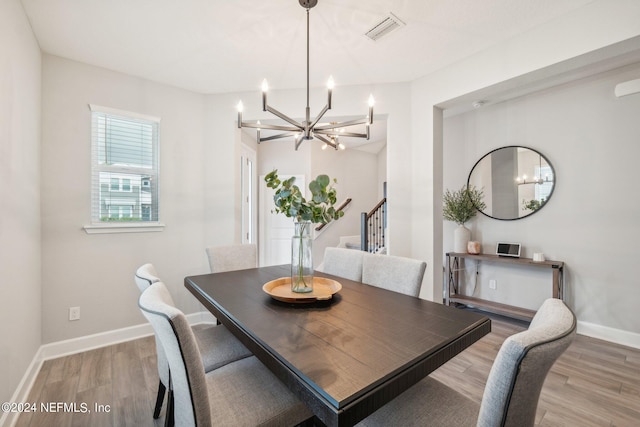 dining area featuring hardwood / wood-style floors and a notable chandelier