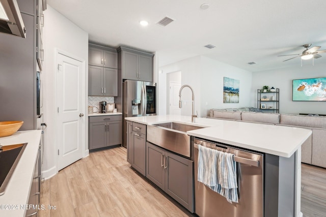 kitchen with gray cabinetry, ceiling fan, stainless steel appliances, and sink