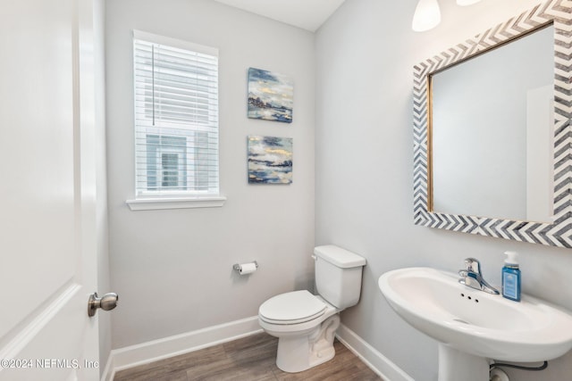 bathroom with hardwood / wood-style floors, toilet, and sink