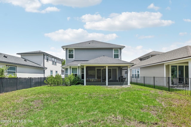 rear view of house with a yard and a sunroom