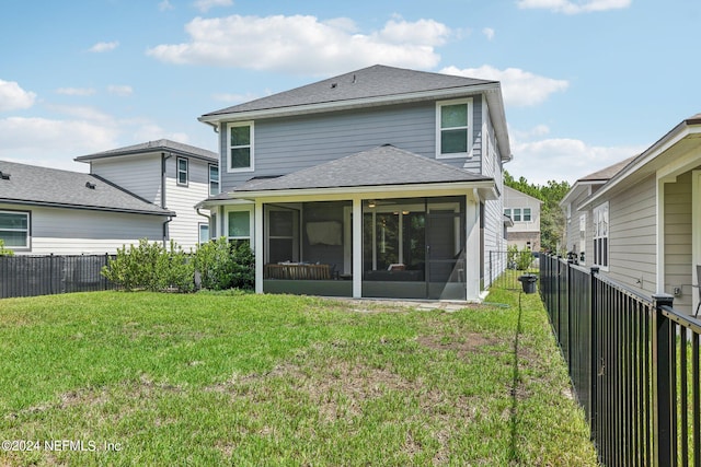 back of house with a sunroom and a yard