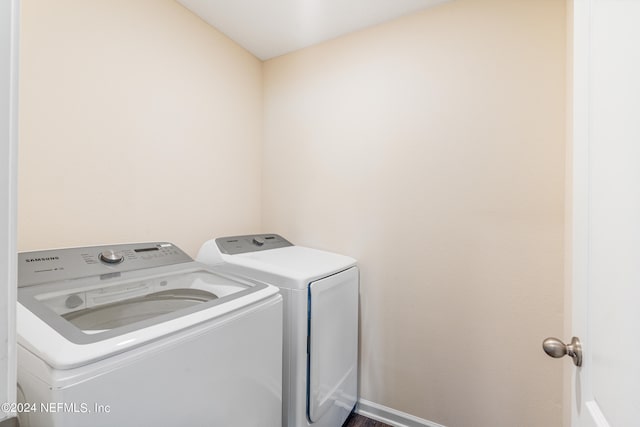 clothes washing area with baseboards, laundry area, and washing machine and clothes dryer