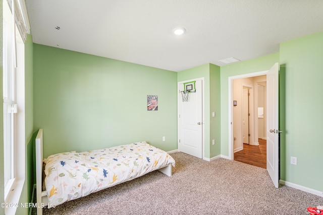 bedroom with visible vents, carpet, and baseboards