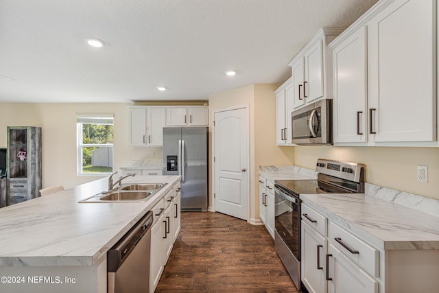 kitchen with dark wood-style flooring, white cabinets, stainless steel appliances, and a sink