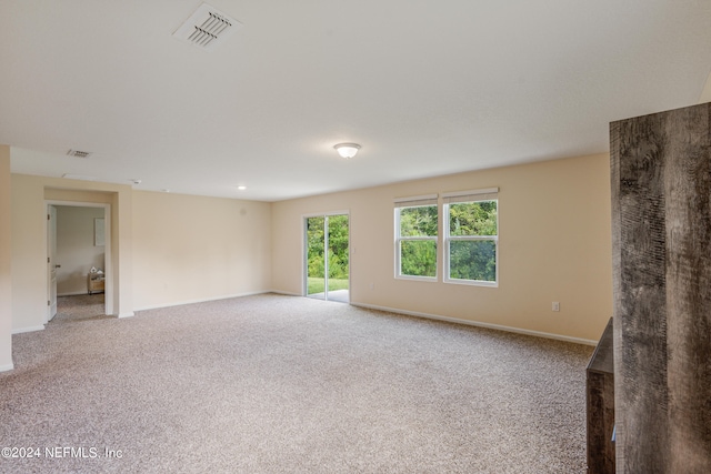 empty room featuring visible vents, baseboards, and carpet