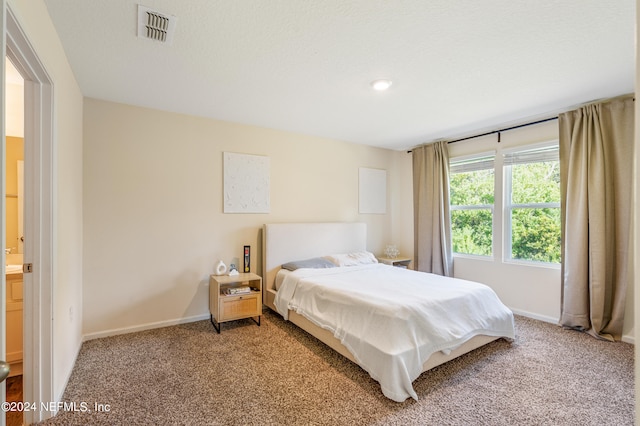 bedroom featuring baseboards, visible vents, and light carpet