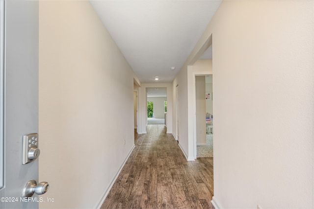 hall featuring wood finished floors and baseboards