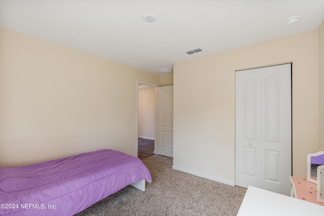 bedroom featuring visible vents, baseboards, a closet, and light carpet