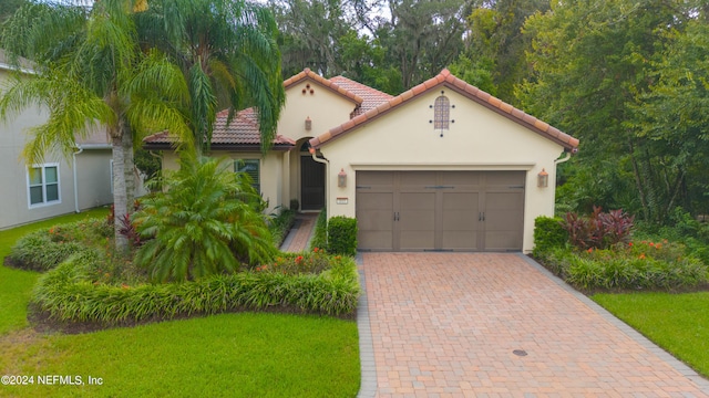 mediterranean / spanish-style house with a garage and a front yard