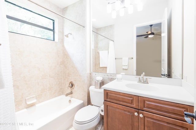 full bathroom featuring toilet, tile walls, tiled shower / bath combo, ceiling fan, and vanity