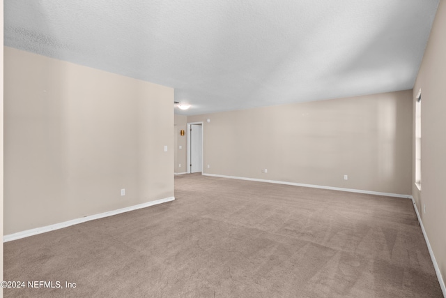 unfurnished room featuring carpet floors and a textured ceiling