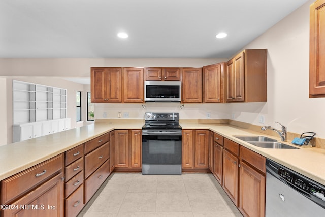 kitchen featuring kitchen peninsula, sink, light tile patterned floors, and stainless steel appliances